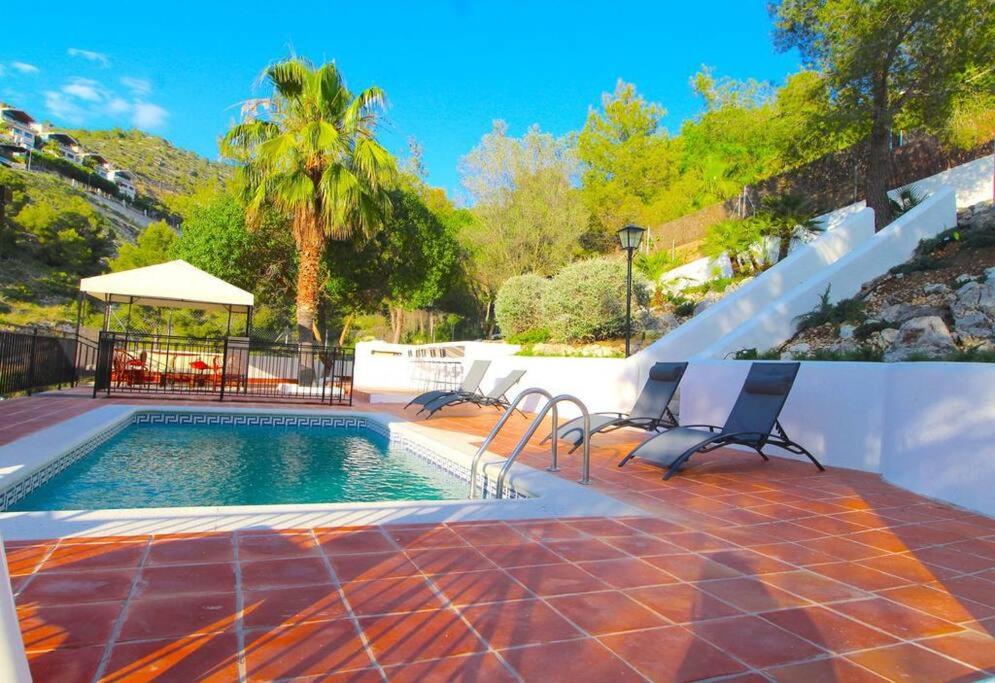 錫切斯的住宿－Vila Sitges, big house with pool，一个带椅子的游泳池和一个凉亭