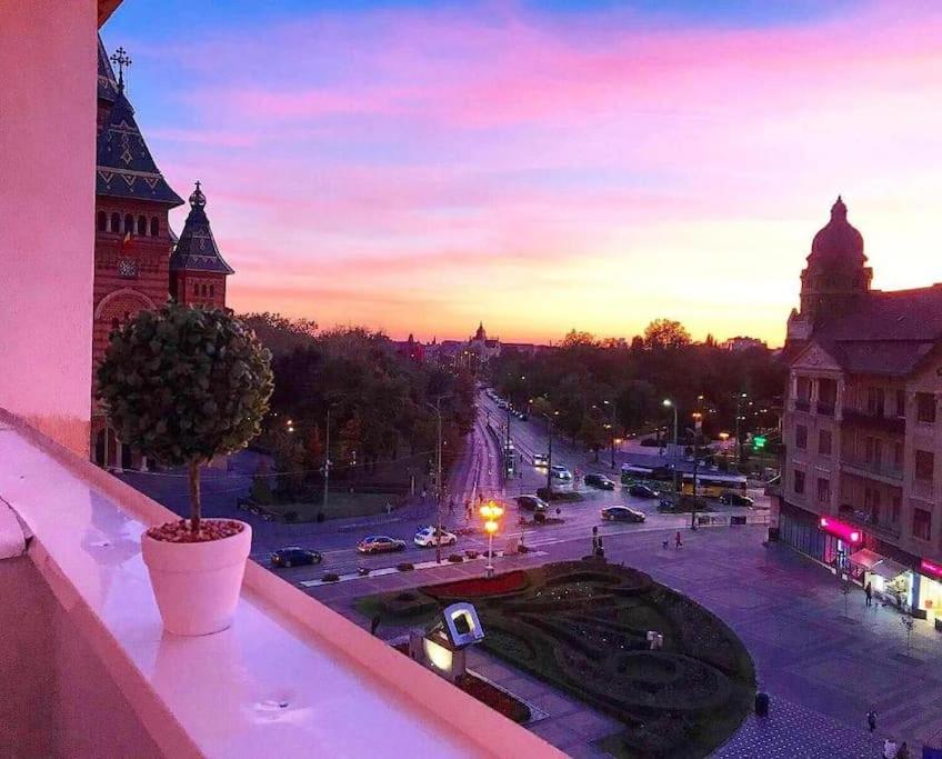 uma vista para a cidade ao pôr-do-sol a partir de uma varanda em Joy City Stay Victoriei 7E-30 2 em Timisoara