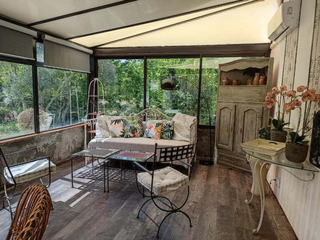 a screened in porch with a couch and a table at Villa les Doms in Mazan