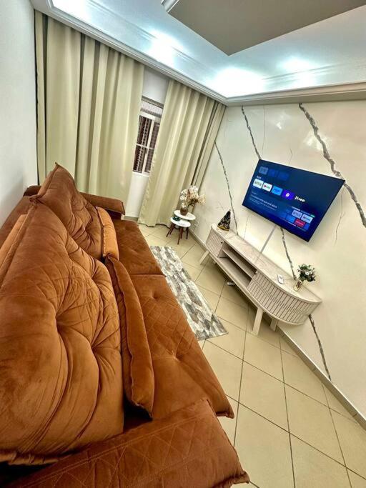 a living room with a couch and a flat screen tv at Apartamento 5 a 4 min da Basílica in Aparecida