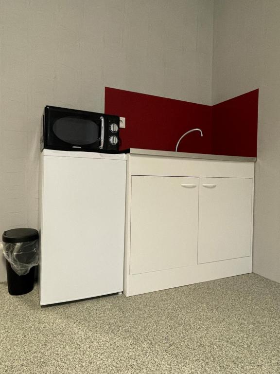 a microwave sitting on top of a white refrigerator at GPHotel/Boardinghaus in Leverkusen