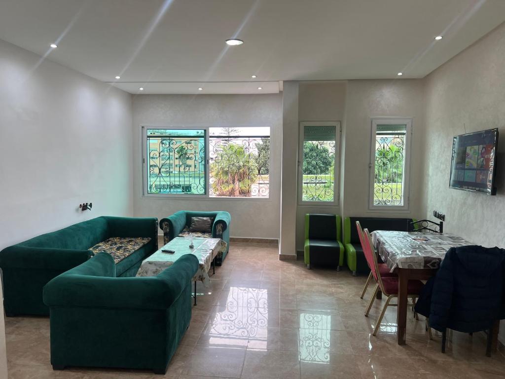 - un salon avec un canapé, des tables et des fenêtres dans l'établissement Résidence Faouazi, à Casablanca