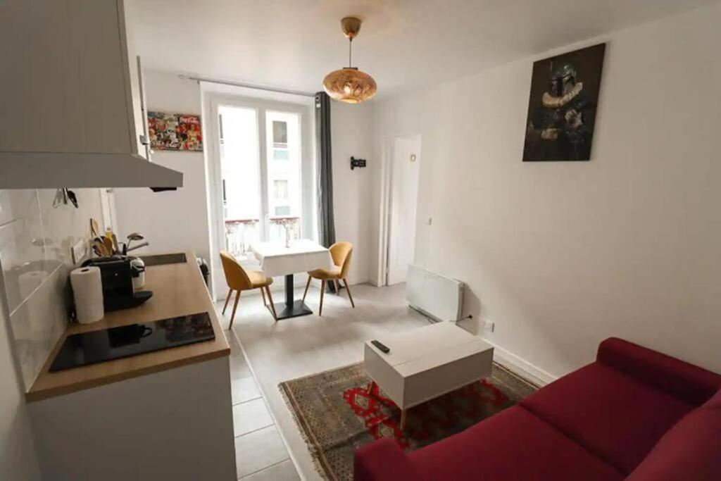 een woonkamer met een rode bank en een tafel bij Appartement 4 personnes Oberkampf in Parijs