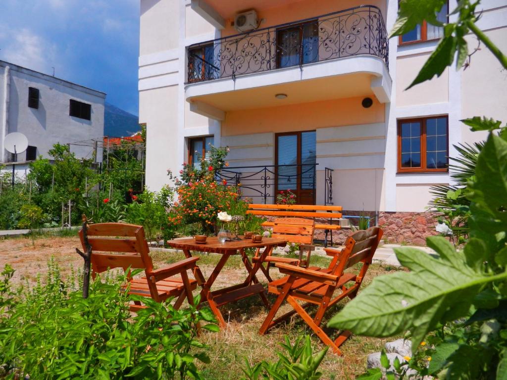 een tafel en stoelen voor een huis bij Guest house Villa Leonardo in Herceg-Novi