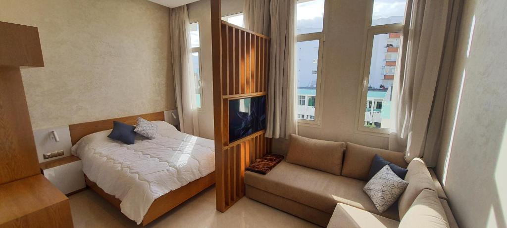 - une chambre avec un lit, un canapé et une fenêtre dans l'établissement Le Petit Bijou, à Tetouan