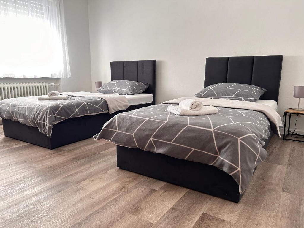 2 camas en un dormitorio con suelo de madera en Hotel & Restaurant Dalmacija Polch, en Polch