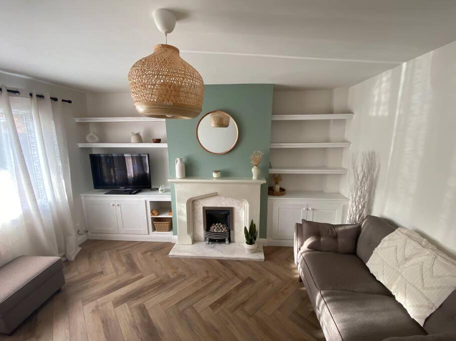 uma sala de estar com um sofá e uma lareira em 3BD Sanctuary in Beeston, Nottinghamshire em Beeston