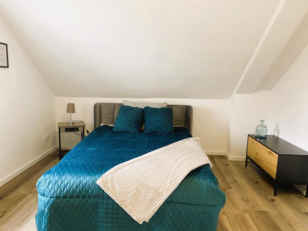 - une chambre avec un lit et une couette bleue dans l'établissement Wohnen am Schlosspark, à Bad Salzuflen