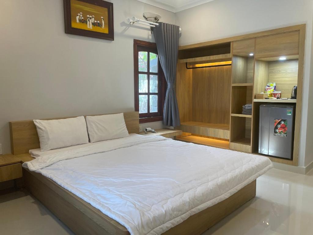a bedroom with a large bed with a television at H&ograve;n Cau Resort & Restaurant in Tuy Phong