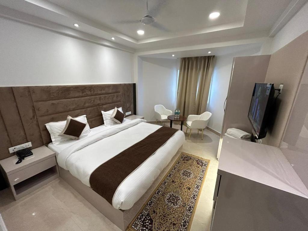 a bedroom with a large bed and a television at Hotel President Agra near Taj mahal in Agra