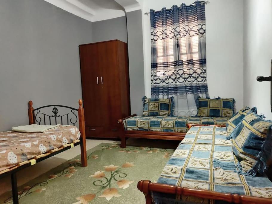 Cette chambre comprend 2 lits et une fenêtre. dans l'établissement Appartement F3 équipé, spacieux près du centre, à Biskra