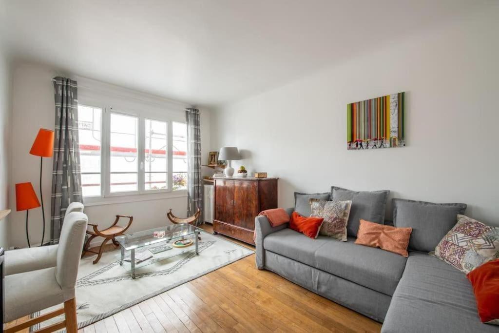 ein Wohnzimmer mit einem Sofa und einem Tisch in der Unterkunft PARIS 6EME - Studio in Paris