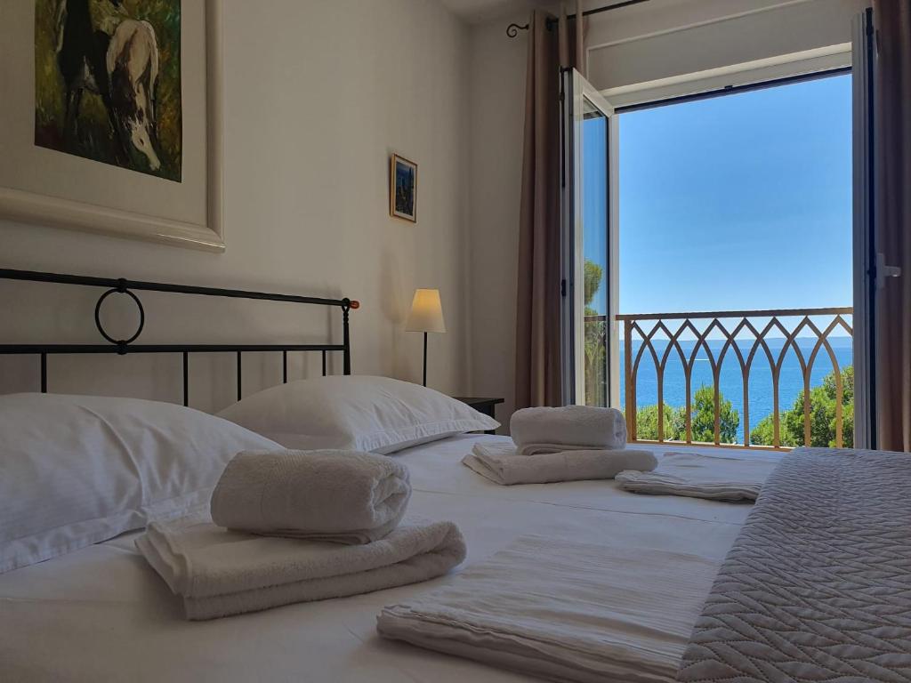 a bedroom with three beds and a large window at Inas Place in Baška Voda