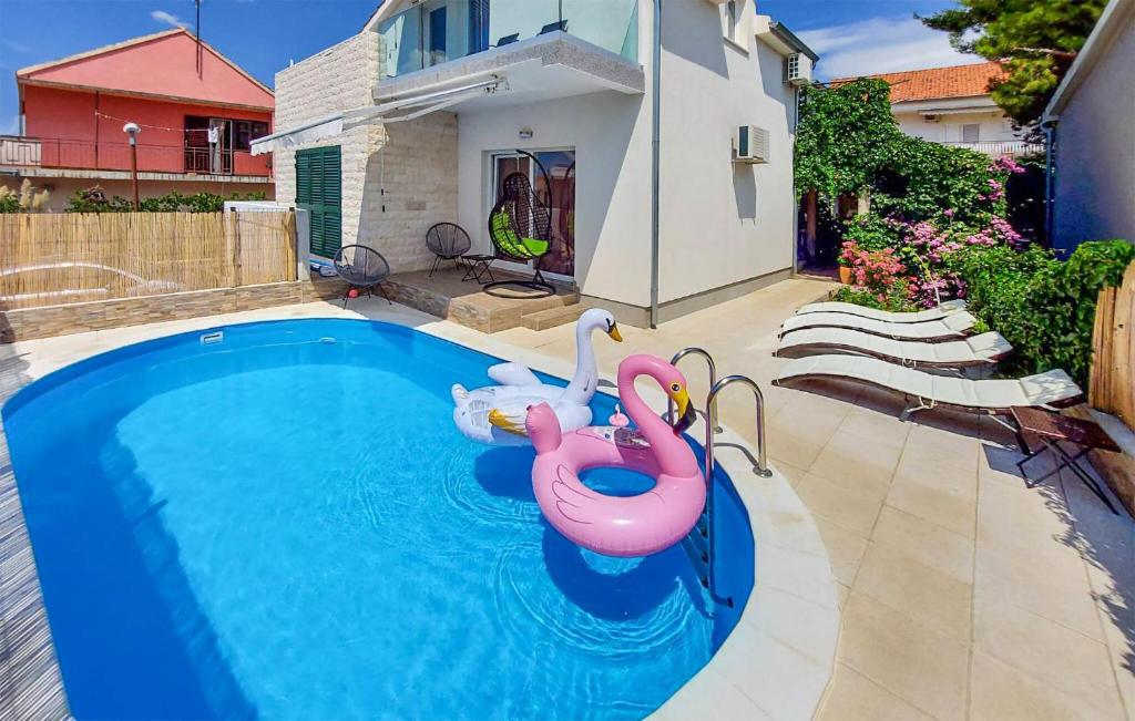 - une piscine avec deux flamants gonflables dans l'eau dans l'établissement Stunning Apartment In Brodarica, à Brodarica
