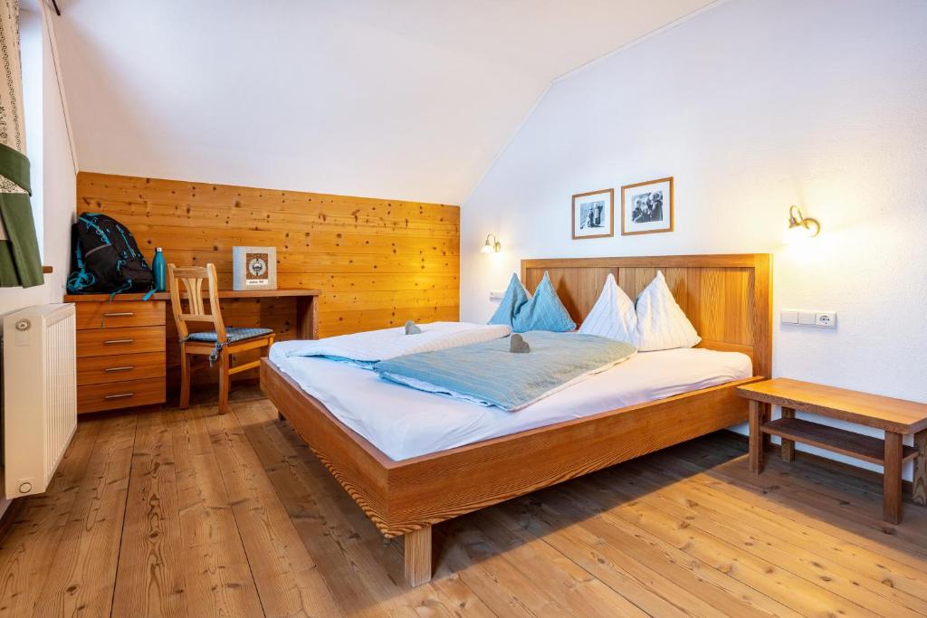 a bedroom with a bed and a desk and a chair at Lechnerhof Apt 1 in Braies