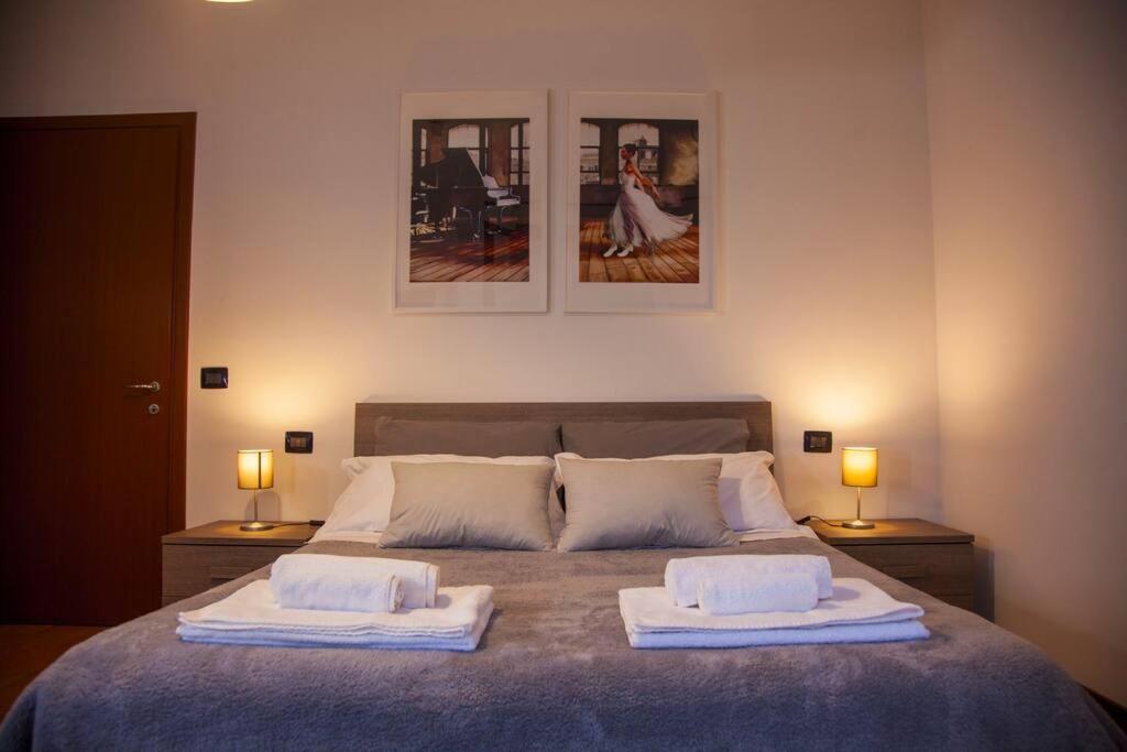 [Montecatini Terme] ''Lo Zizzolo'' Casa Moderna e Tranquilla في مونتيكاتيني تيرمي: غرفة نوم عليها سرير وفوط بيضاء