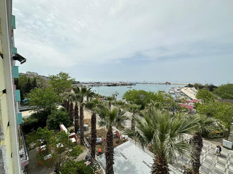 uma vista para um corpo de água com palmeiras em شقة بإطلالة على الشاطئ والكورنيش 5 Apartment with beach and sea view em Silivri