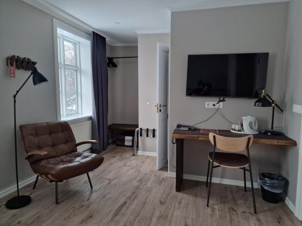 a living room with a desk and a chair at Gistihúsið - Lake Hotel Egilsstadir in Egilsstadir