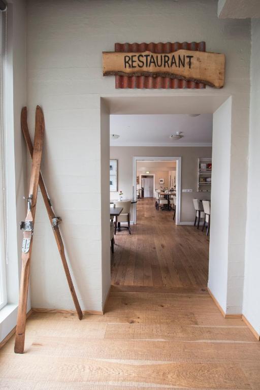 a dining room with a restaurant sign on the wall and a room with a wooden at Gistihúsið - Lake Hotel Egilsstadir in Egilsstadir