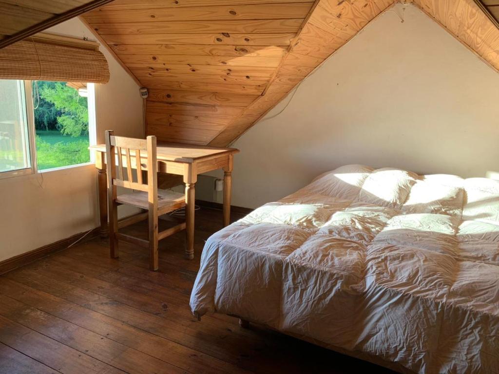 a bedroom with a bed and a wooden desk at La Calma Casa Quinta - PISCINA, PARRILLA, WIFI - in Pilar