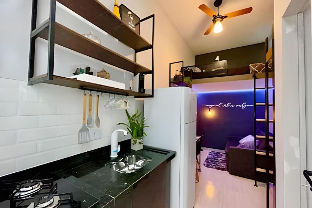 a kitchen with a counter and a refrigerator at Studios Tiny House - Viva Essa Experiência in Sao Paulo