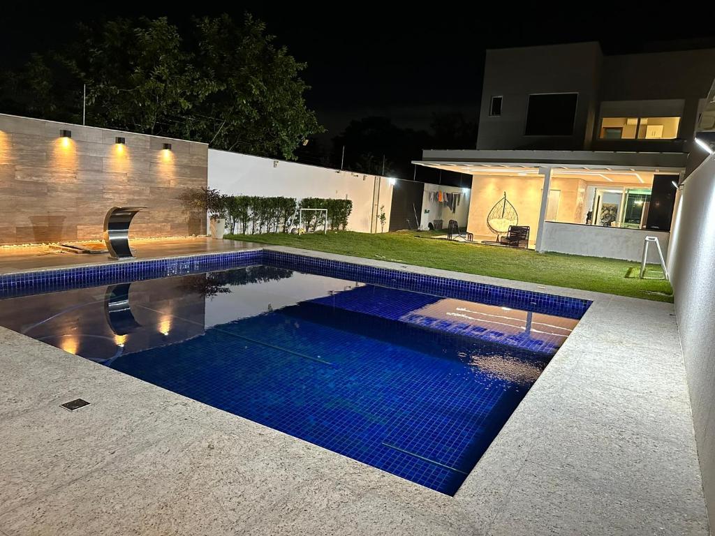 a swimming pool in front of a house at night at Casa Pampulha - espaço Gourmet com Piscina Aquecida in Belo Horizonte