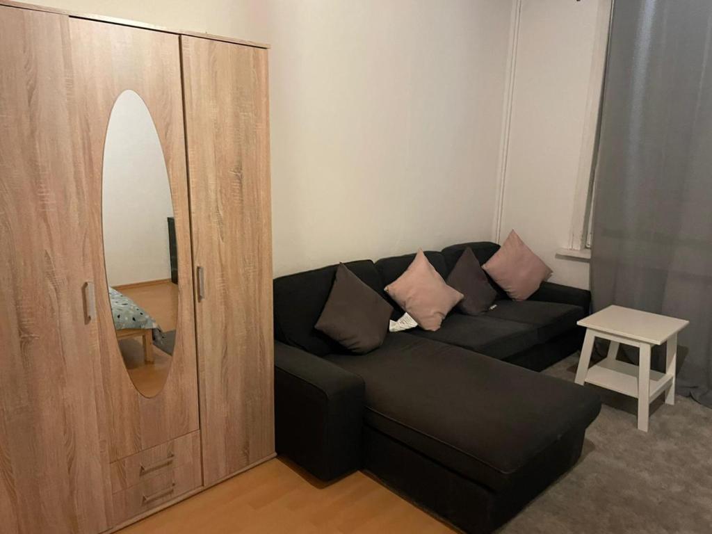 a living room with a black couch and a mirror at Wohnung im Rebenring in Braunschweig