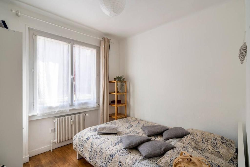 a bedroom with a bed with pillows on it at Lyon Chambre pour une personne chez Dalia in Lyon