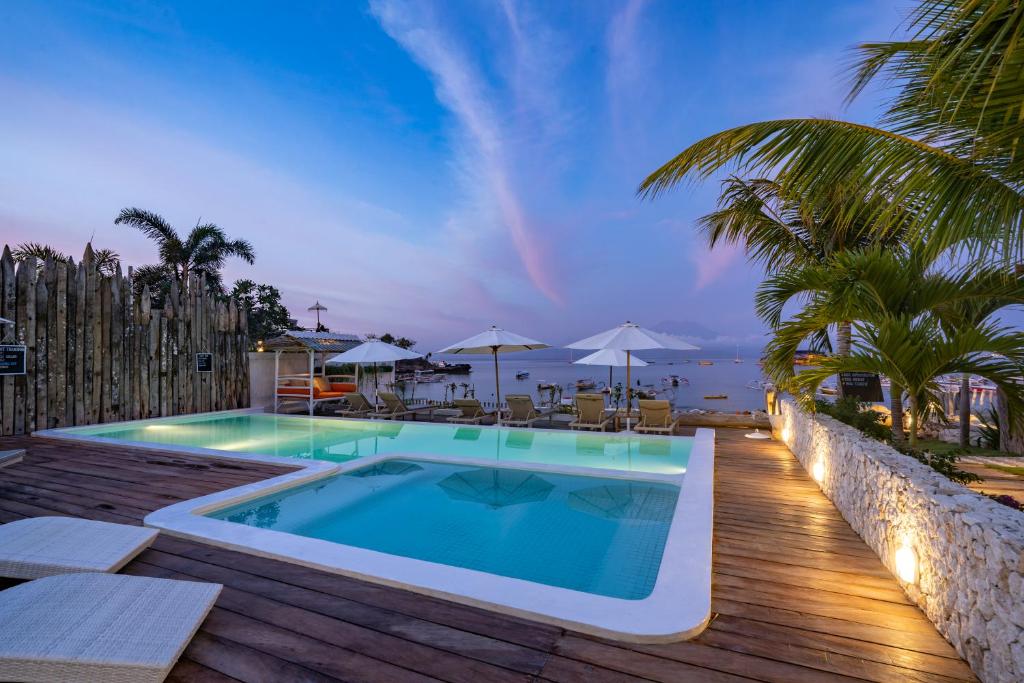 a swimming pool on a deck with a view of the ocean at Paus Putih Hotel in Nusa Lembongan