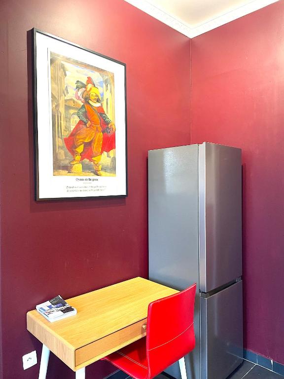 a kitchen with a table and a refrigerator at La Domus Lemaitre 1, plain-pied, Wifi , TV, parking, jardin 
