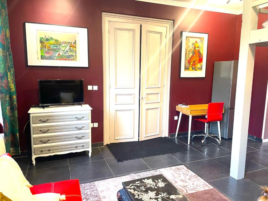 a living room with a tv and a dresser and a desk at La Domus Lemaitre 1, plain-pied, Wifi , TV, parking, jardin 