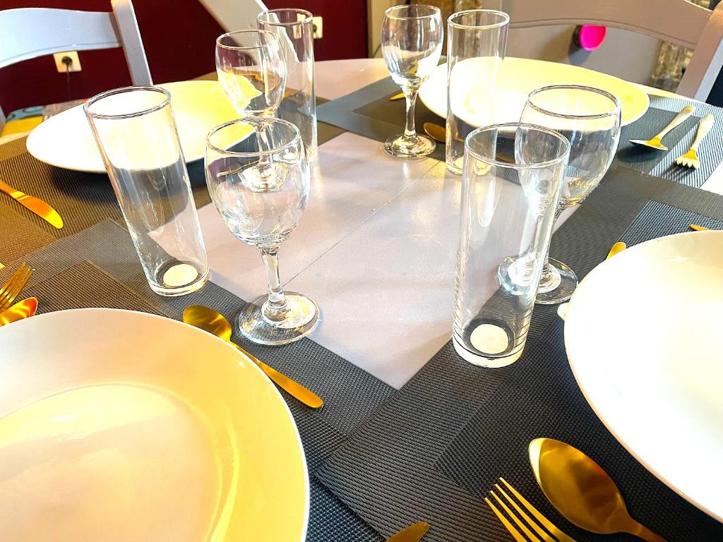 a table with wine glasses and plates on it at La Domus Lemaitre 1, plain-pied, Wifi , TV, parking, jardin 