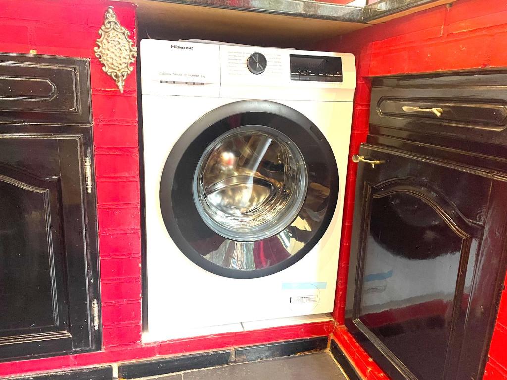a washing machine in a room with a red wall at La Domus Lemaitre 1, plain-pied, Wifi , TV, parking, jardin 