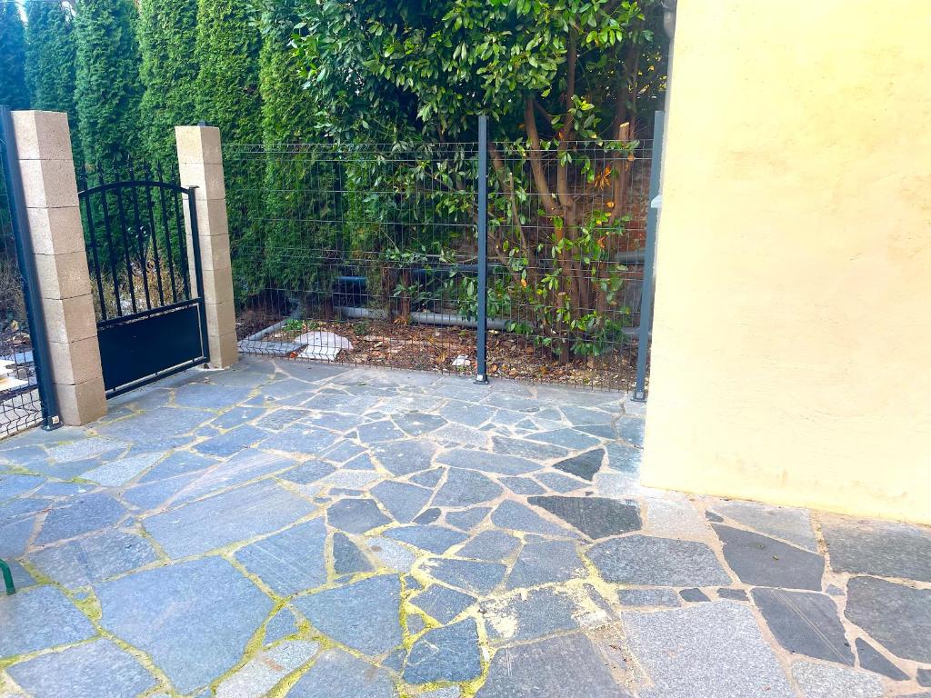 a stone patio with a gate and a fence at La Domus Lemaitre 1, plain-pied, Wifi , TV, parking, jardin 