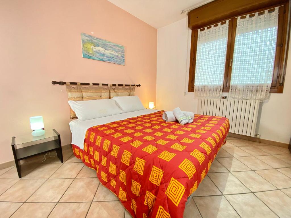 1 dormitorio con 1 cama con manta roja y amarilla en Nel Cuore della Natura - Parcheggio gratuito - Wi-Fi, en Mezzolara
