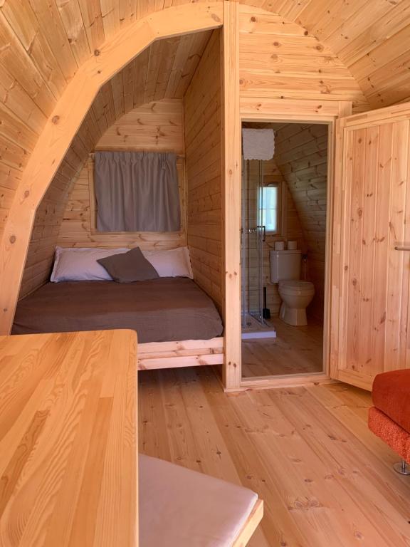 uma cama num quarto de madeira num chalé de madeira em Agriturismo Nonno Mario em Fossone dʼAdige