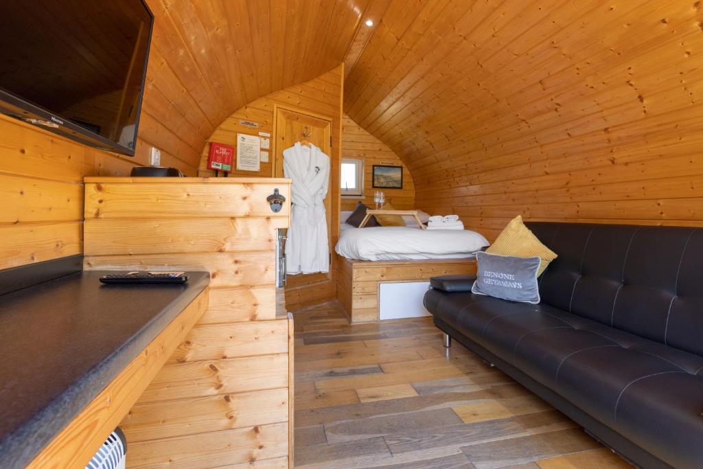 Habitación con sofá y cama en una cabaña en Benone Getaways, en Derry Londonderry
