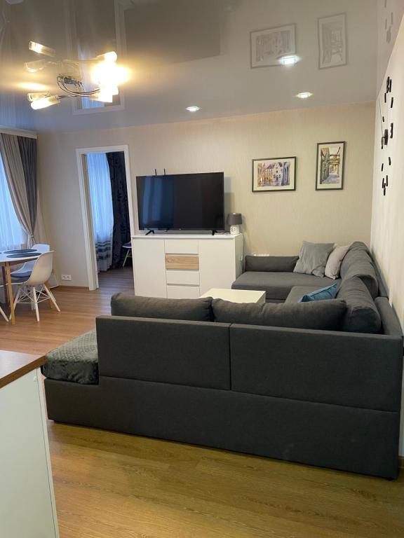 uma sala de estar com um sofá e uma televisão de ecrã plano em Like a home Linda Apartment em Narva