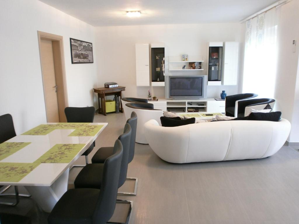 a living room with a white couch and a table at Apartments Bora in Ližnjan
