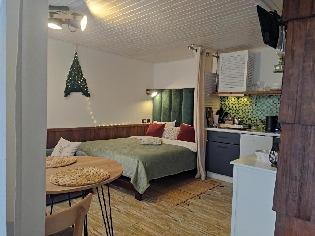 ein Schlafzimmer mit einem Bett und einem Tisch sowie eine Küche in der Unterkunft gonta cottage in Slawske