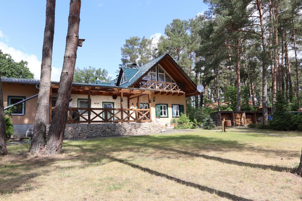 ein Haus im Wald mit Bäumen in der Unterkunft Ferienwohnung Habicht Villa-Pälitzsee in Großzerlang