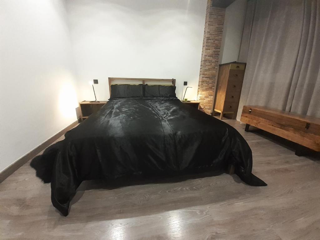 una camera da letto con un letto con un piumone nero di LA BOHEME a Telde