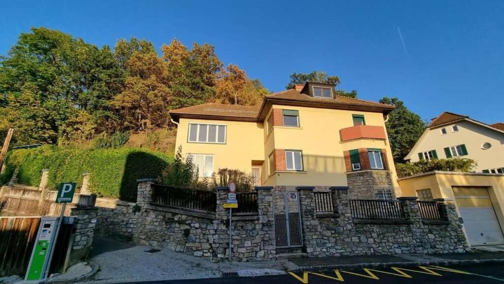 a large yellow house with a stone wall at Appartement Huber - TOP1 in Bruck an der Mur
