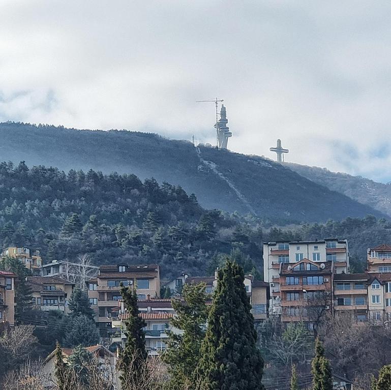 a hill with a cross on top of a city at Luxury Apartment with parking space in Vodno