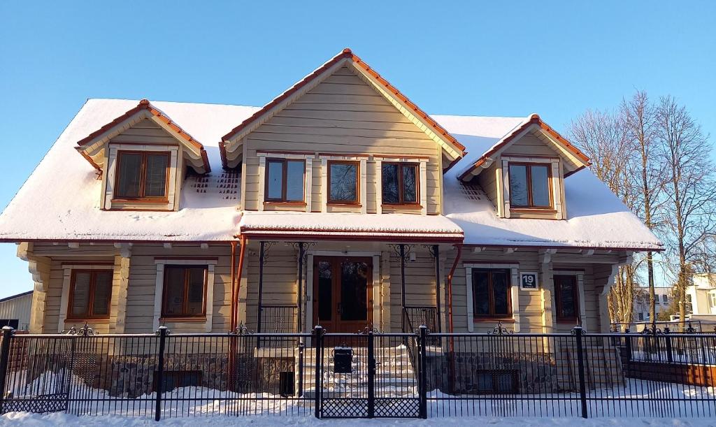 une maison recouverte de neige dans l'établissement S Neries 19 apartamentai su parkingu, à Šiauliai