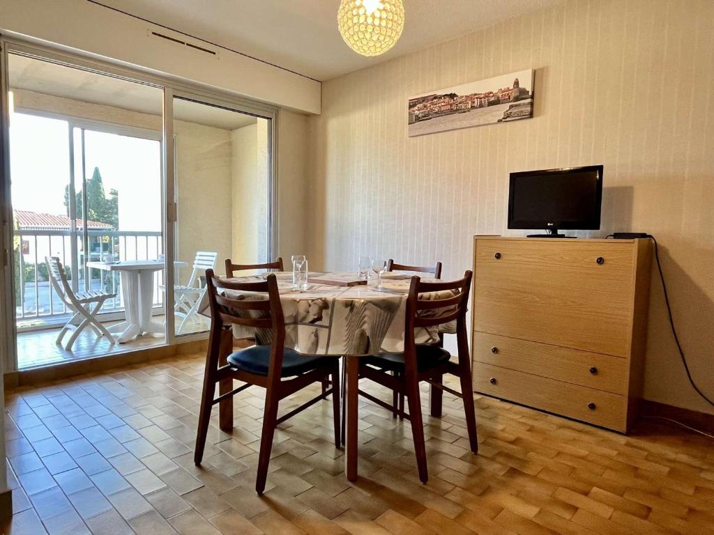 une salle à manger avec une table avec des chaises et une télévision dans l'établissement Appartement 2 pièces à 400m de la plage avec parking privé, loggia et ménage inclus - Argelès-sur-Mer - FR-1-225-247, à Argelès-sur-Mer