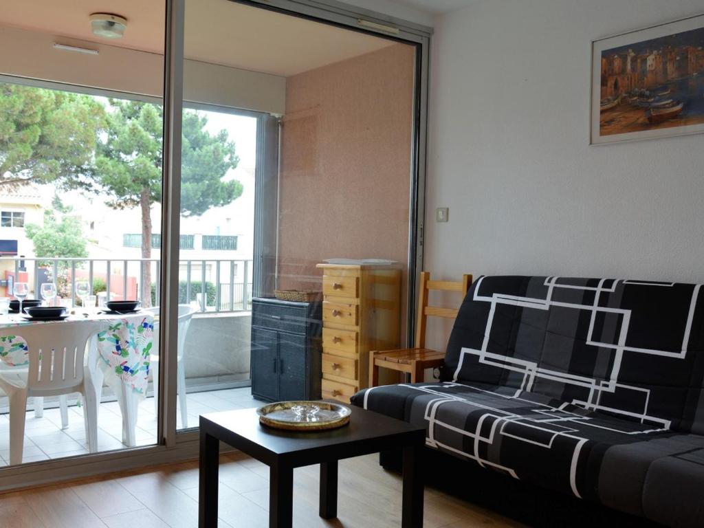un salon avec un canapé et une table dans l'établissement Appartement 2 pièces avec piscine, proche plage et commerces - Argelès-sur-Mer - FR-1-225-296, à Argelès-sur-Mer