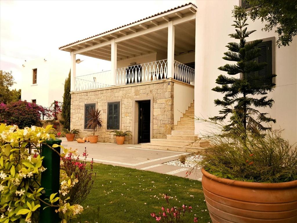 een huis met een veranda en een binnenplaats met bloemen bij Villa Hekim in Bodrum City