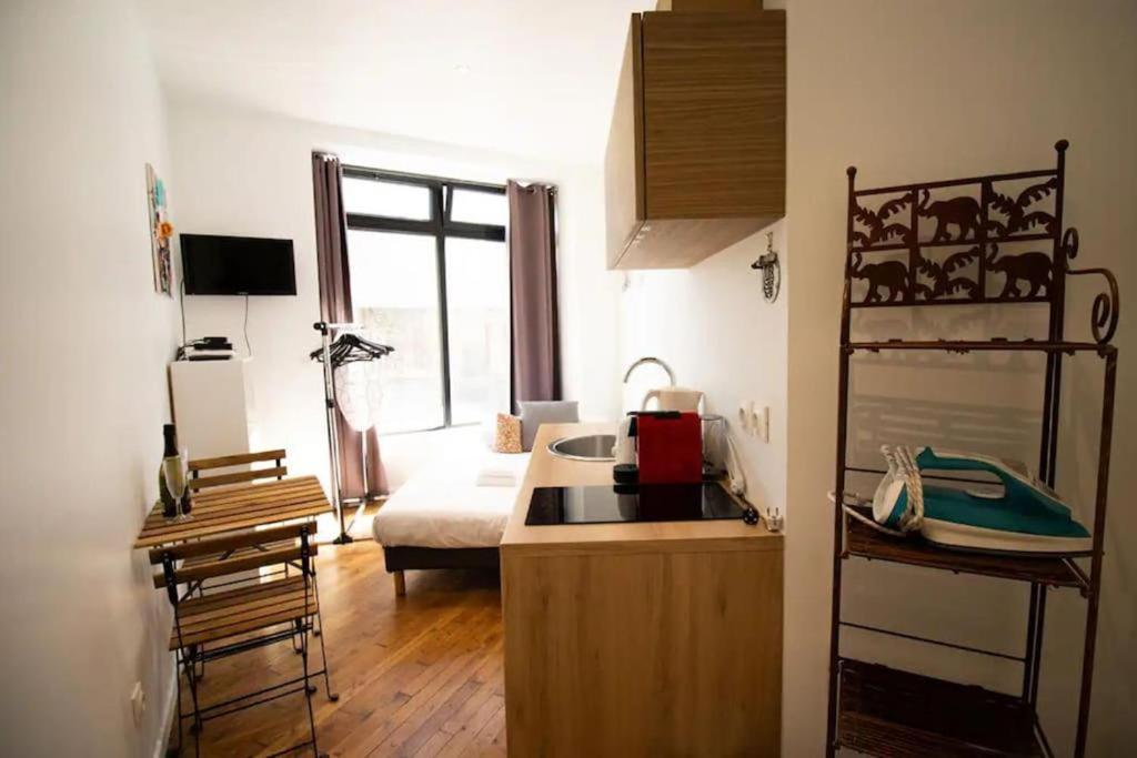 une cuisine avec un évier et un salon dans l'établissement Studio 2 personnes proche Gare du Nord, à Paris