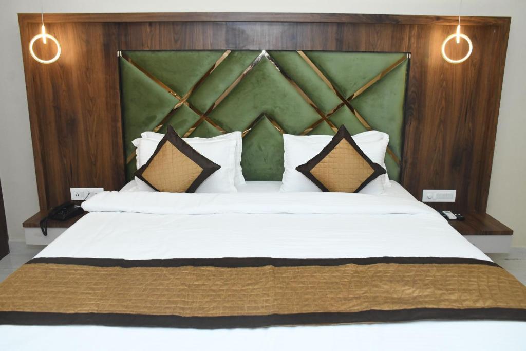 a bedroom with a large white bed with brown pillows at HOTEL IMPERIAL in Aurangābād